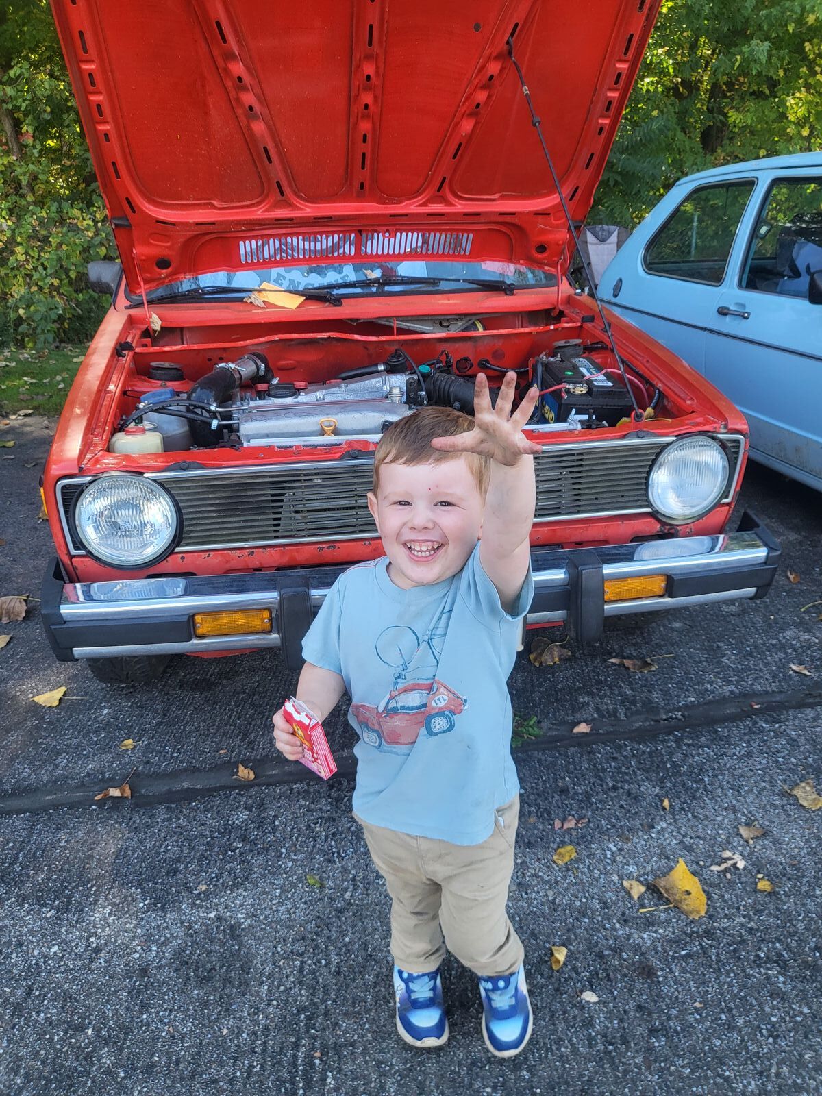 Family at the shop — Roger running, hood up, a small helper in front